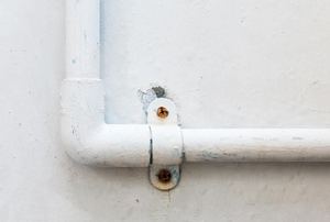 A pipe line on the side of a house.