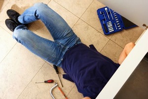 A plumber under a sink.
