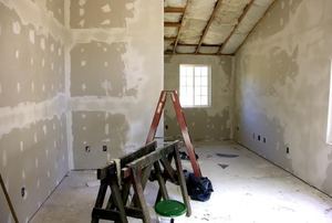 Room with drywall, tape, and mud on walls.