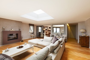 living room with large couch, fireplace, coffee table, and skylight