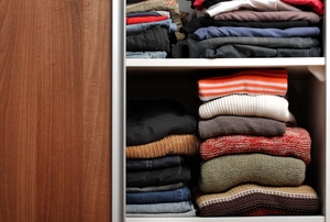 closet sliding door open, exposing folded clothes