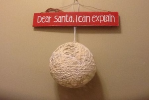 An ornament made out of string hangs on a wall.