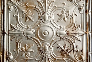 A tin ceiling tile with rust spots.