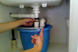 Removing the P-trap from a kitchen sink.