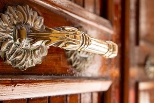 wood door with ornate brass handles