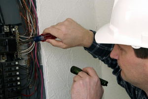 man working on a circuit breaker box