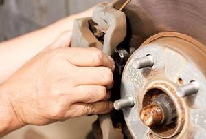 person replacing brake pads