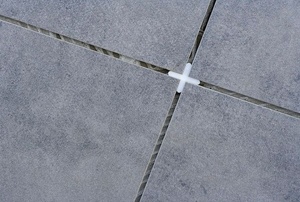 Tile spacer at the intersection of four gray tiles