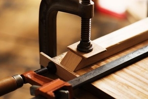 a table clamp holding a piece of wood on a table