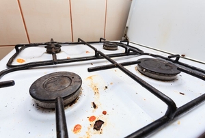 Grease and food debris remain stuck to a stovetop.