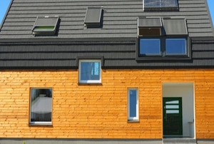passive house with wood siding and slate roof