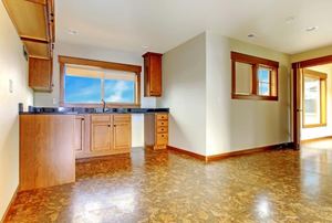An empty kitchen with cork flooring.