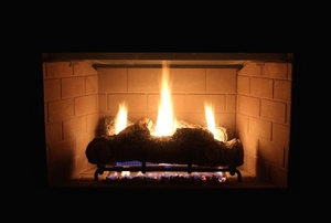 A gas fireplace lit in a dark room.