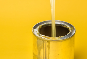 A can of rubber adhesive against a yellow background.