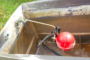 inside of a toilet tank showing a red ballcock