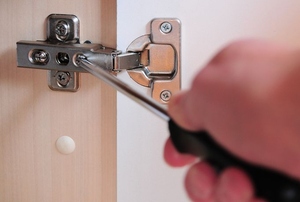 Screwing a bracket into a cabinet