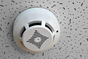 A smoke detector in a drop ceiling.