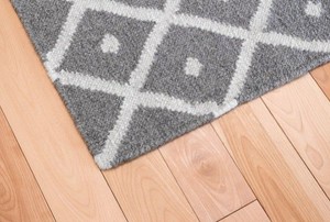grey and white rug on light wood floor