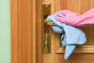 gloved hand cleaning a doorknob