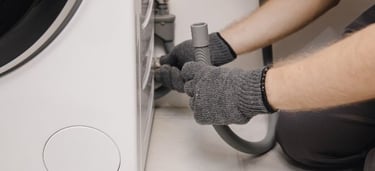 Gloved Hands Adjusting Washing Machine Drain 1  613467 