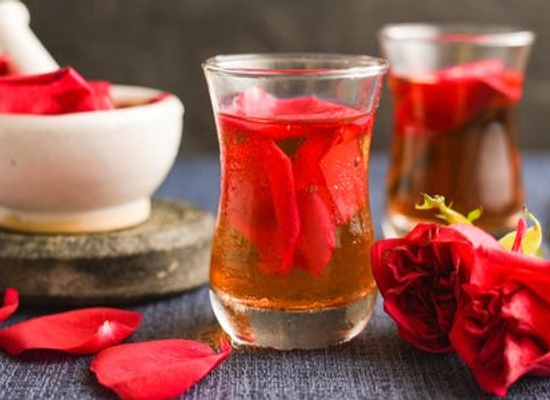 rose petals in water with mortar and pestle on table