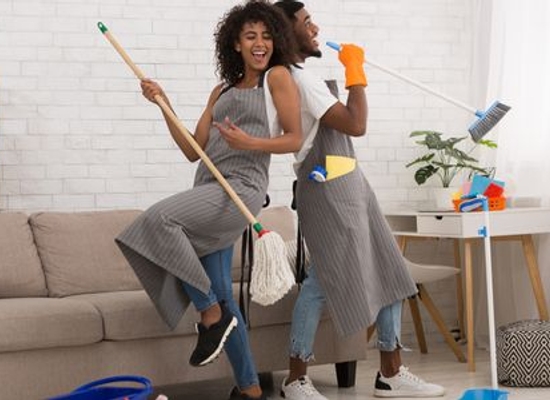 woman and man having fun with their spring cleaning tools