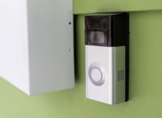doorbell with camera on green wall