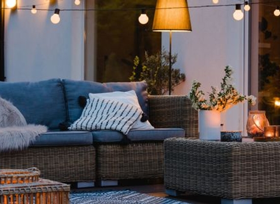 natural wicker furniture on a patio or deck with string lights
