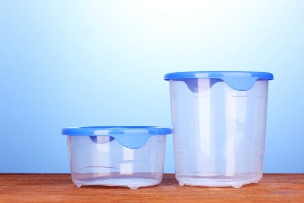 A couple of plastic containers against a blue background. 