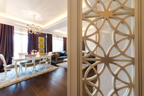 A modern room divider with a dining room in the background. 