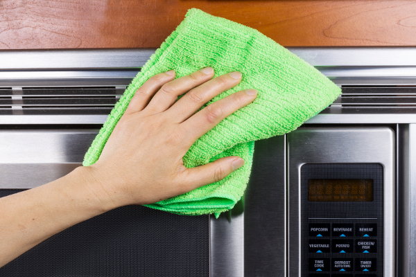 A microfiber cloth cleaning a microwave. 