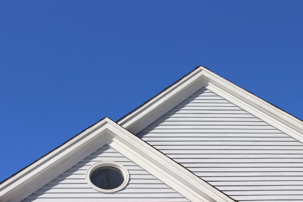 A gabled roof against a blue sky.