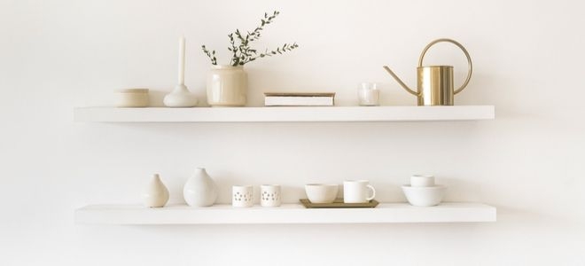 floating shelves with simple ceramic items and brass watering can