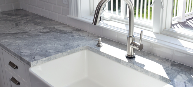 deep farmhouse sink with marble countertop