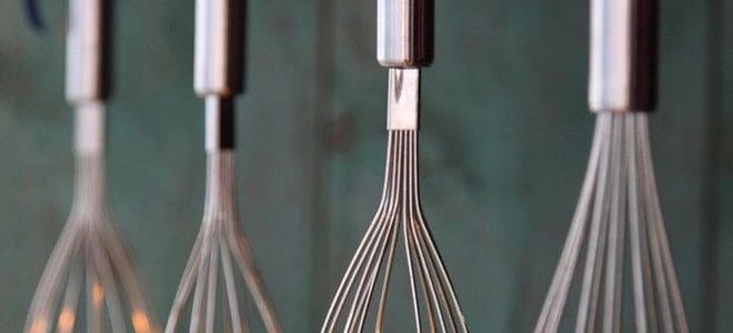 A light fixture made of whisks.