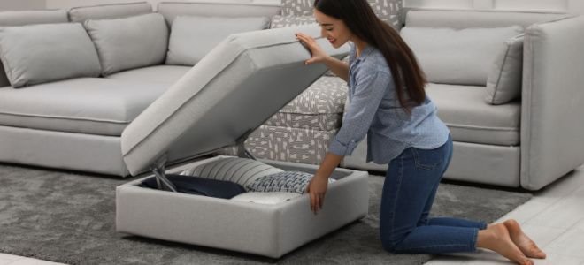 smiling woman opening ottoman with storage inside