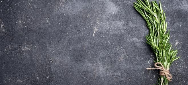 A concrete counter with a sprig of herbs on it.