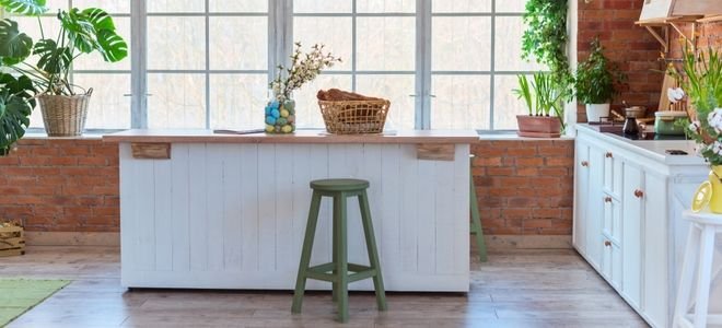 simple kitchen island in loft style room with large windows for natural light and plants