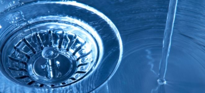 Water flowing into a stainless steel sink.