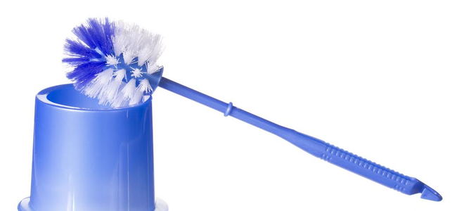 A blue toilet brush leaning against its holder. 