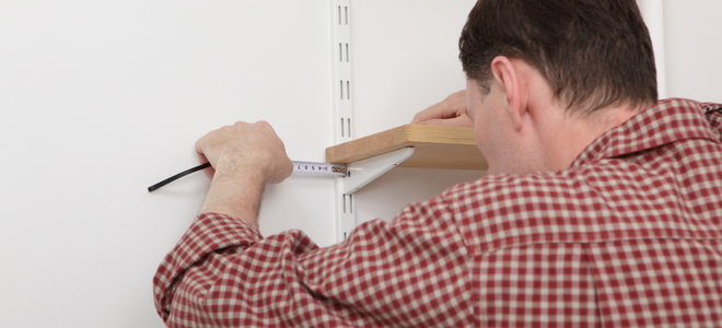 Man placing shelf into joint on a shelving unit