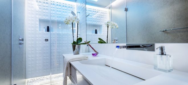 Modern bathroom with white counters and frameless shower