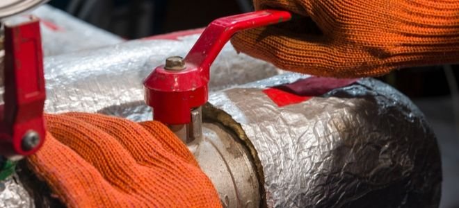 gloved hands adjusting insulated water heater
