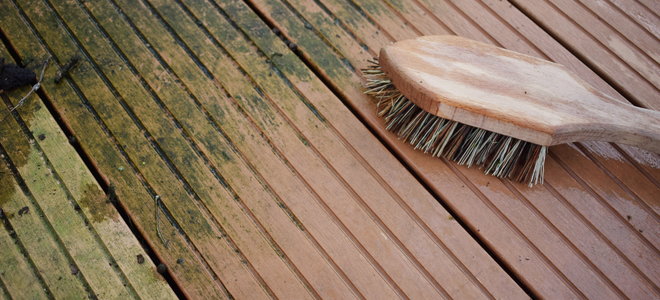 scrub brush on a partially cleaned deck