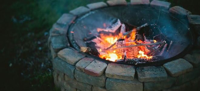 A stone firepit in a backyard. 