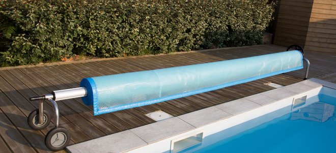 A pool cover next to a pool.