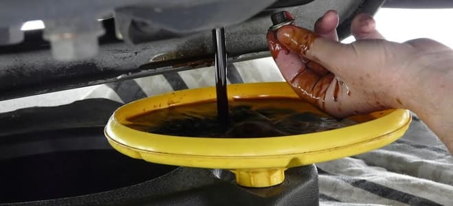 A drip pan with oil leaking into it. 