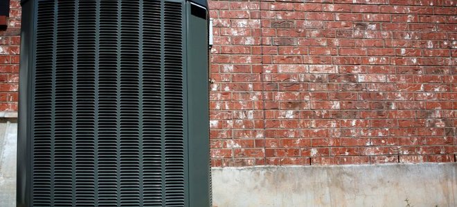 A heating unit outside of a brick building.