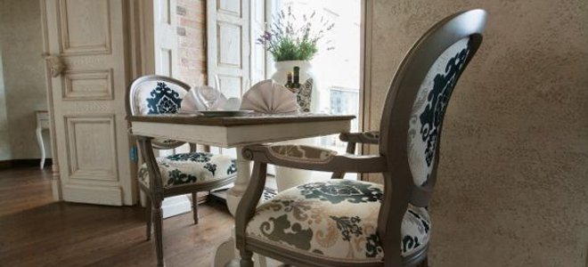 Victorian style chairs and small table in front of an open door