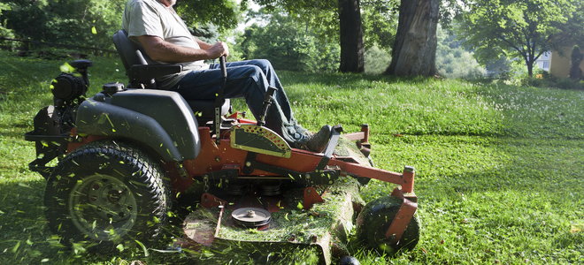 A man uses a lawn mower.
